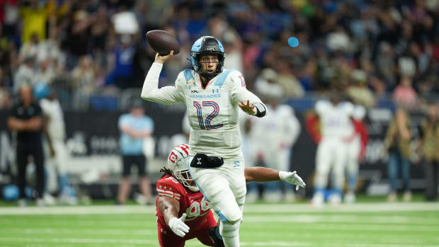 May 13, 2023; San Antonio, TX, USA; Arlington Renegades quarterback Luis Perez (12) throws a pass as DC Defenders defensive lineman Joe Wallace (99) reaches for his feet in the first half at the Alamodome. Mandatory Credit: Daniel Dunn-USA TODAY Sports  